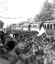 photographie noir et blanc : une foule devant des wagons