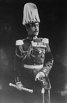 photographie noir et blanc : un homme moustachu en grand uniforme avec un casque à plumes