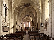 Photographie en couleurs d'une église dont le clocher est revêtu d'ardoises.