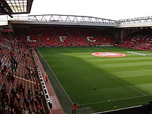 The interior of a stadium which has red seats.