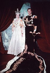 Elizabeth in crown and robes next to her husband in military uniform