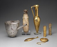 Artifacts including large metal tweezers, decorated and inscribed vessels, gold sheaths, and a ewer marked for King Aspelta found in Nuri pyramid 8. Museum of Fine Arts, Boston.