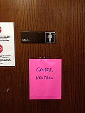 Un post-it "Gender neutral" collé sur la porte des toilettes pour hommes